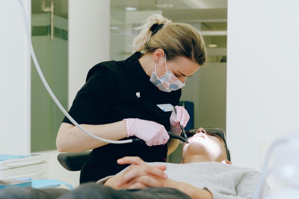 Female dentist performing a dental check-up and treatment on a patient in a modern dental clinic